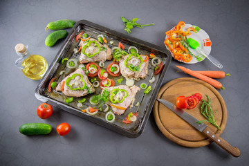 Raw chicken with ingredients for cooking on a gray background. Selective focus