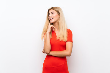 Teenager girl over isolated white background thinking an idea while looking up