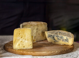 Three pieces of cheese. Ripe yellow cheese and blue cheese on a wooden board. Food, wine and romantic, cheese and delicatessen. Text area space