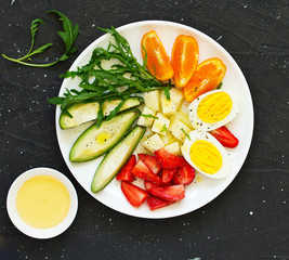 Breakfast and healthy snack of eggs, avocado, cheese and strawberries.
