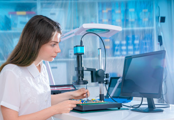 Woman worker in laboratory of electronics devices