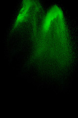 Green particles explosion on black background. Color dust splash use for abstract background.