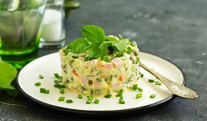 Russian traditional salad Olivier with vegetables and sausage.