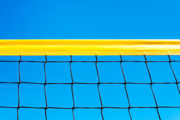 yellow colored summer games ball background beach volleyball or tennis net against blue sky for...