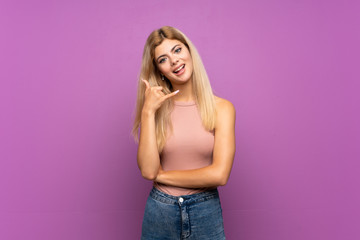 Teenager girl over isolated purple background making phone gesture. Call me back sign