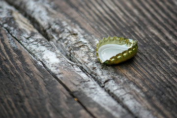 Beer bottle cap on wooden background. Soft selective focus. Close-up.