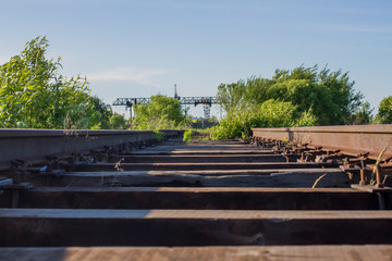 Fototapeta na wymiar old railway with grass on the background of a crane