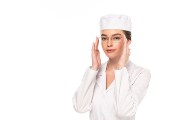 young doctor in white coat touching glasses isolated on white