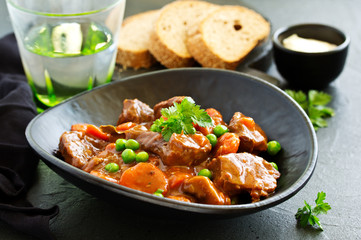 Beef stew in Burgundy. With carrots, onions, peas and champignons in wine. View from above.