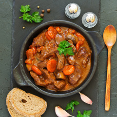 Beef stew in Burgundy. With carrots, onions, peas and champignons in wine. View from above.