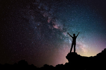 Happy freedom woman on the mountain  with starry night sky milkyway. freedom and victory concept.