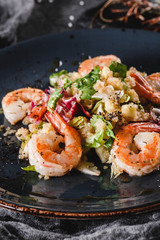 Quinoa salad with shrimp and mixed greens in bowls over grey background. Healthy food, clean eating, dieting, top view