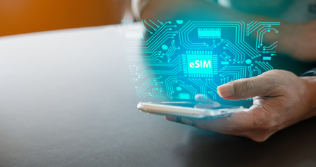 Close up of Man using a phone with eSIM technology. Mobile device with a chip on a circuit board art.eSIM(Embedded SIM) - electronic sim phone new mobile communication technology. - obrazy, fototapety, plakaty