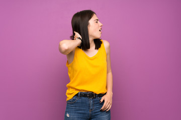 Young woman over isolated purple wall with neckache