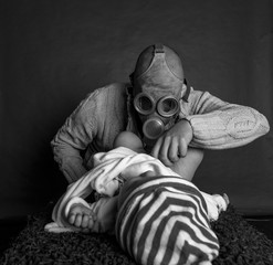 Young Dad cleaning his baby's dirty ass, changing the stinky diaper in a gas mask, fatherhood and...