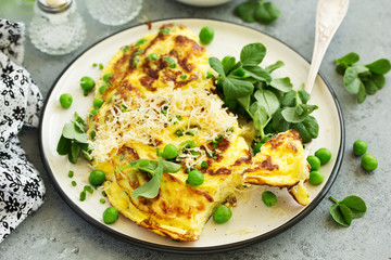 Breakfast. Frittata Italian omelet with green peas and salad.