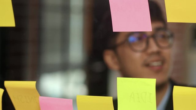 Group of Asian creative men workshop and brainstorm in front of mirror board. Young professional business team working create strategy, business situation, startup in Loft office concept. Slow motion.