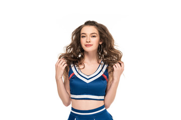 sexy happy cheerleader girl in blue uniform touching hair isolated on white