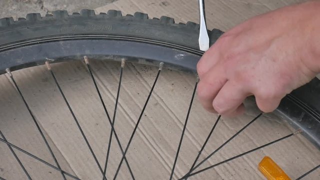 Cyclist or mechanic Repairs tires bicycle. Close up of hands and bicycle flat tire tyre.