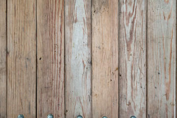 Close-up on a wooden flat surface with cracks on vertical boards with stripes and rings for the construction and manufacture of walls. Industry and natural materials.