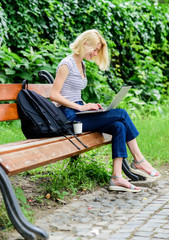Naklejka na ściany i meble Study outdoors. Modern student life. Regular student. Surfing internet. Girl adorable student with laptop and coffee cup sit bench in park. Woman student work with notebook. Learn study explore
