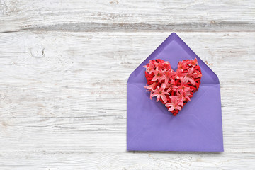 flowers heart in envelope on wooden background 