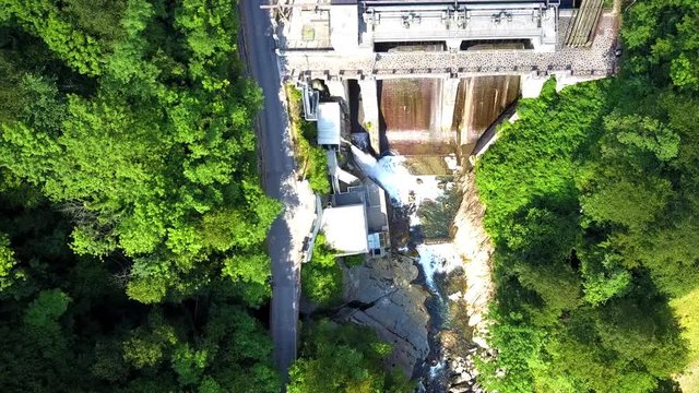 Vista aerea di una Diga di un lago di montagna. Edificio Liberty immerso nel verde. Live uscita di acqua da una delle condutture