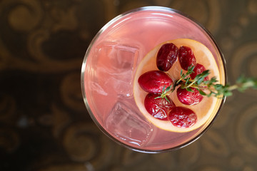 pink drink with a lemon and cranberry garnish