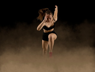 Fototapeta premium Sporty woman running. Smoke background