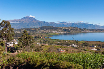 Beautiful view of the San Pablo lake, with surrounding houses and towns, and the Cotacachi volcano in the background, on sunny and bright morning. Ecuador South America