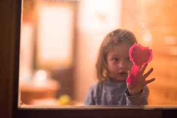 little cute girl playing near the window