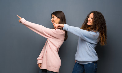 Teenager friends pointing to the side to present a product