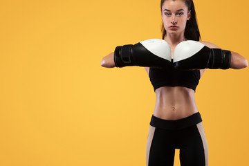 Sportsman, woman boxer fighting in gloves. on yellow background. Boxing and fitness concept.