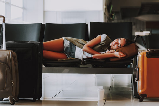 Woman with luggage is sleeping in waiting zone