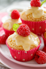 Muffins with white chocolate, fresh raspberries and mint on a ceramic plate, close up. A delicious dessert or breakfast.