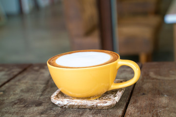 Cup of hot latte art coffee on wood table