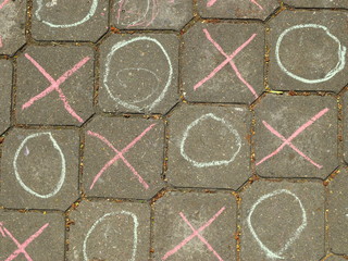 tic-tac-toe are drawn on the paving slab with chalk