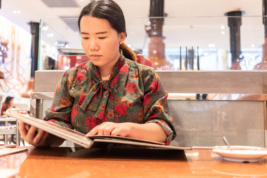 Bangkok, Thailand, Jul 14, 2019 - Asian Woman Looking At The Menu Before Order Food In Japanese Restaurant