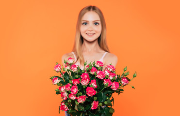 Beautiful, cute, lovely, smiling blonde little girl with happy eyes holds large bouquet of flowers isolated in studio. Birthday, holidays, Valentines day, mothers day concepts.