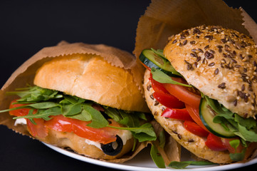 Veggie burger with tomatoes, mozzarella, arugula, paprika and olives
