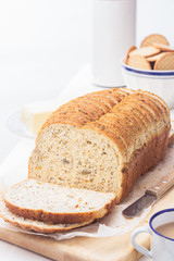 Sliced bread, butter knife and coffee with milk