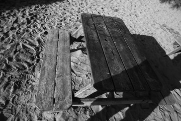 Old bench in sand black and white