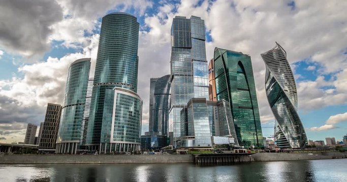 Moscow city, Russia. The main skyscrapers of the capital reflected in the Moscow River. Clouds over the city. Time laps RAW 4K