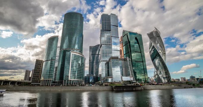 Moscow city, Russia. The main skyscrapers of the capital reflected in the Moscow River. Clouds over the city. Time laps RAW 4K