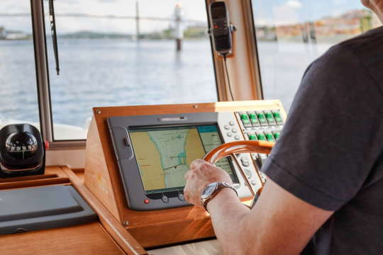 An old man  turning steering wheel to control boat in the sea, navigation