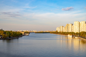 Fototapeta premium Embankment of the river in the city. Beautiful view of the river and a pleasure boat on the pier