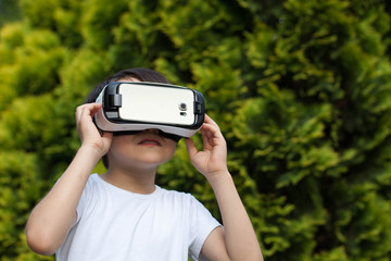 Cute little boy using VR glasses outdoors in a park - Blogger testing augmented reality goggles concept - Gamer exulting during 3D video game playing 