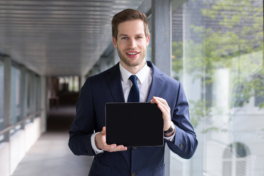 Junger Gesch&auml;ftsmann zeigt die leere Oberfl&auml;che eines Tablet 