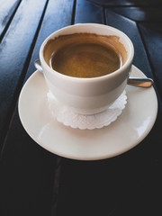 tasty white cup of cappuccino with latte art on wooden table.