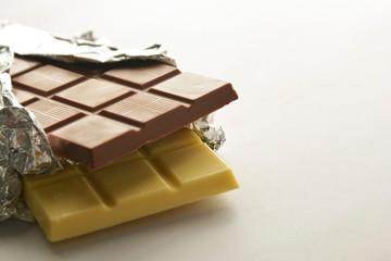 White and milk chocolate isolated. Top view of various chocolate bars with copy space.